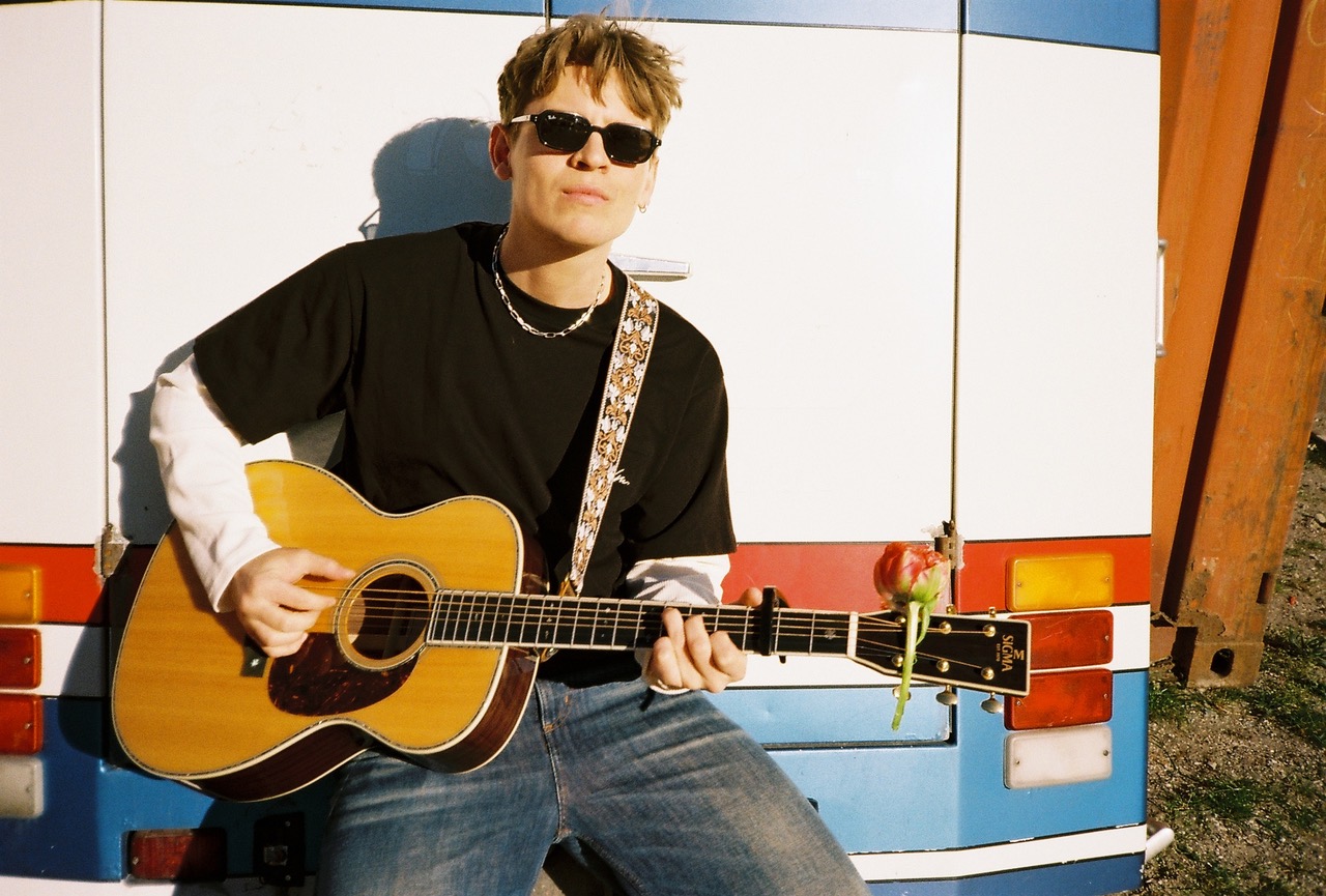 Malte August med guitar og solbriller